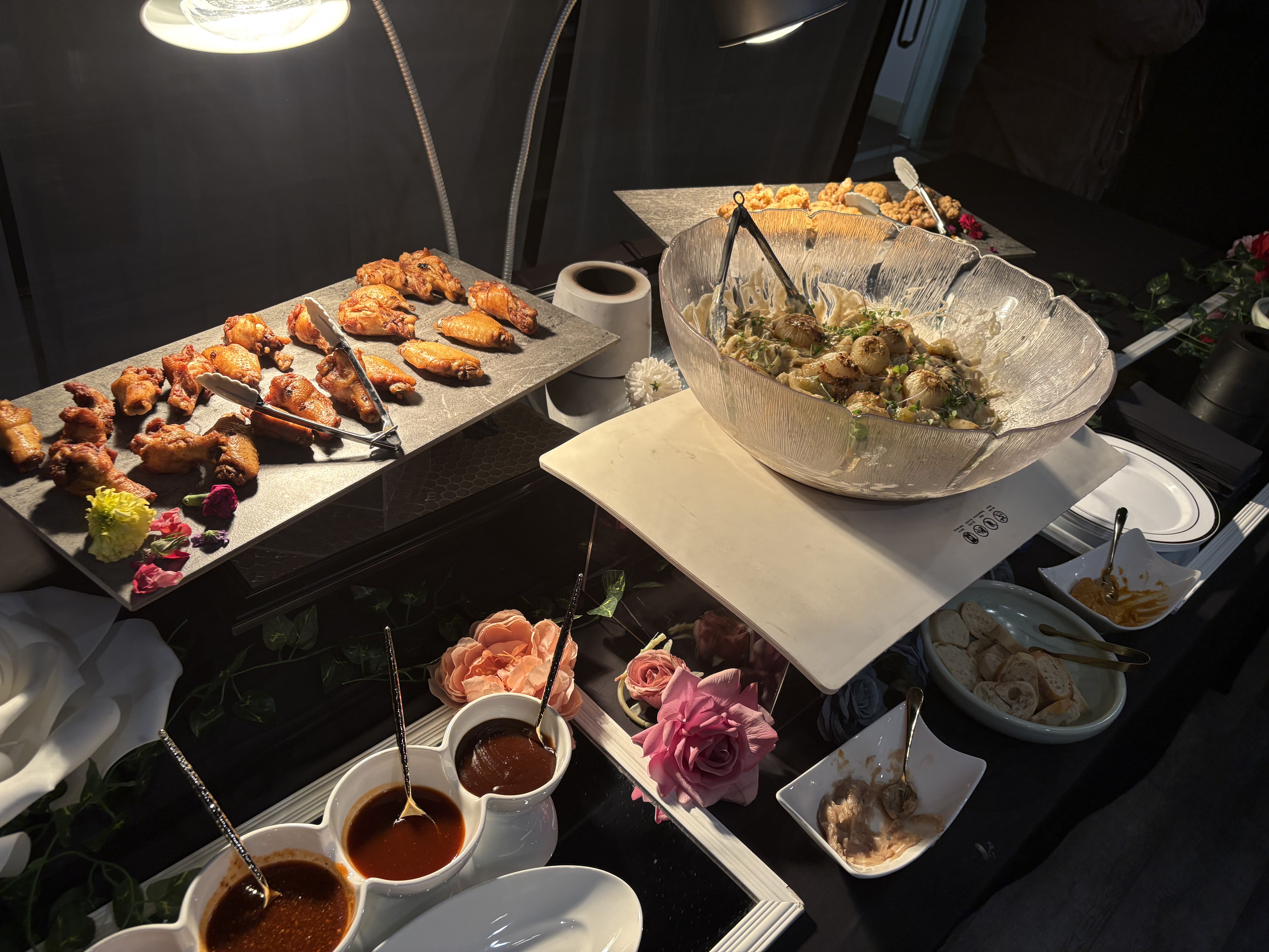 Full catering spread with crispy wings pasta and sauces by Brown Rice Consortium Denver caterer