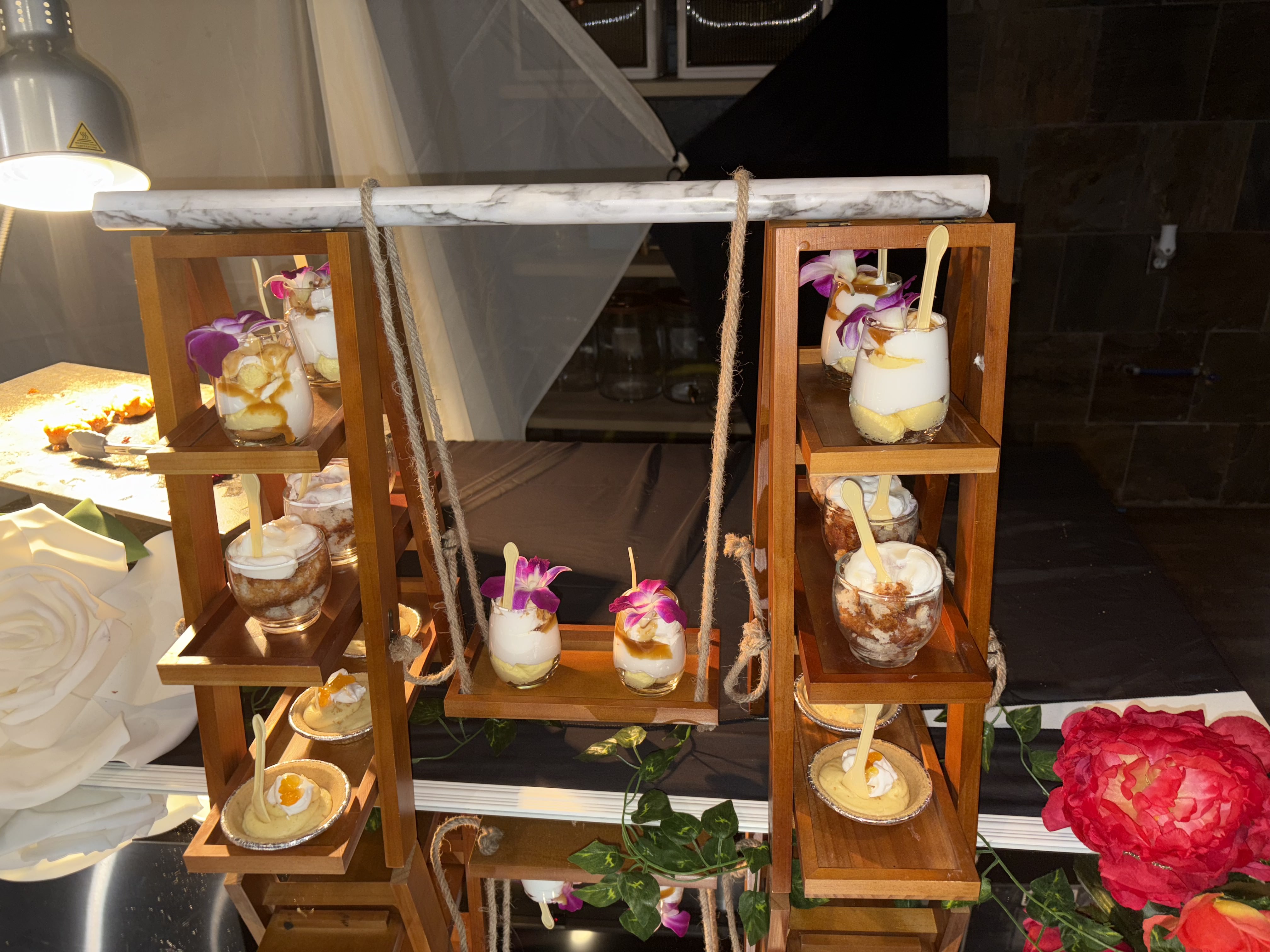 Artisan parfait desserts with orchid garnish displayed on wooden stands by Brown Rice Consortium Denver caterer