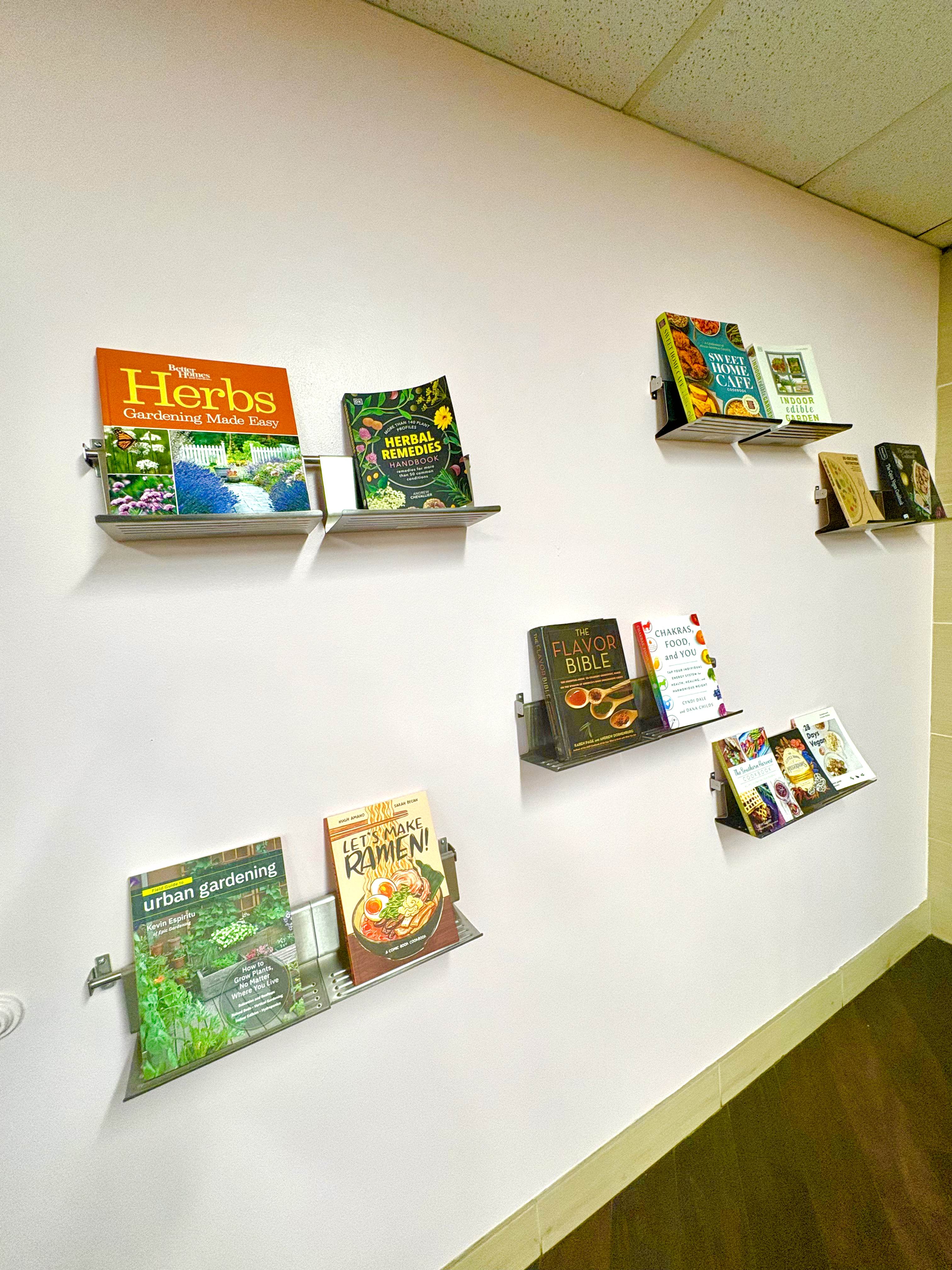 Curated culinary cookbook library wall display at Brown Rice Consortium Denver